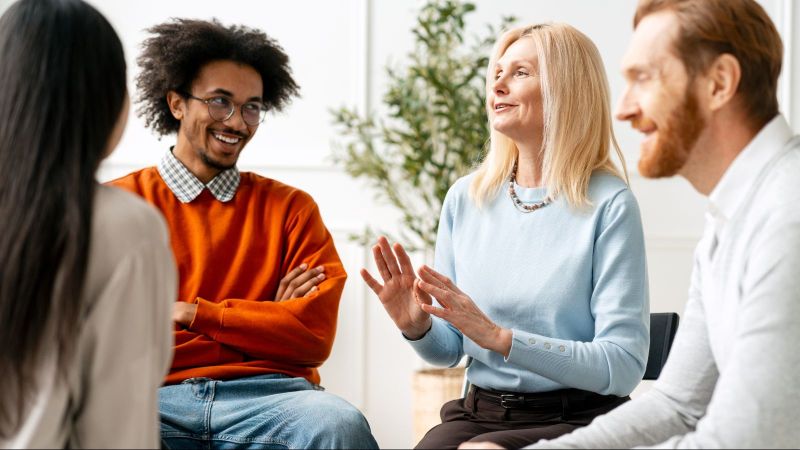 Das Bild zeigt mehrere Menschen, die miteinander in Diskussion sind.