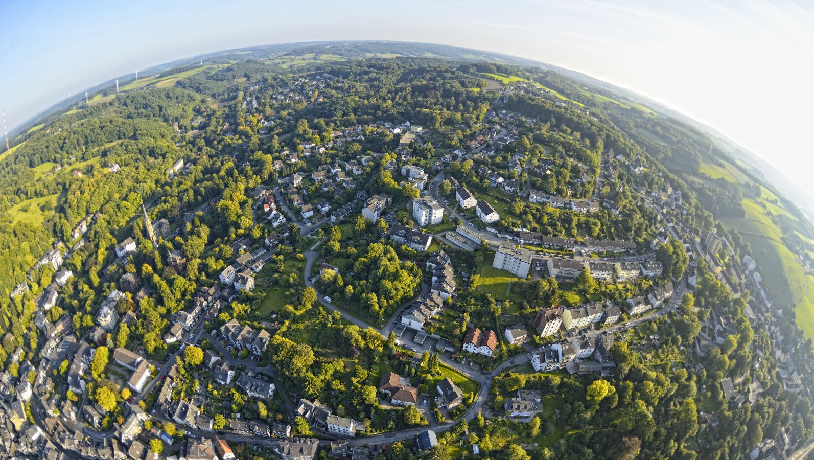 Das Bild zeigt eine von Grün umgebene Landschaft von oben. 