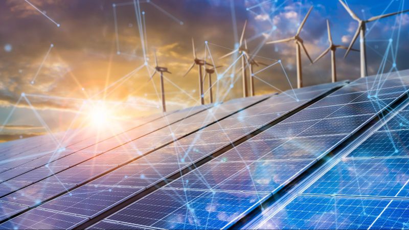 Das Bild zeigt Photovoltaik-Module und Windräder.