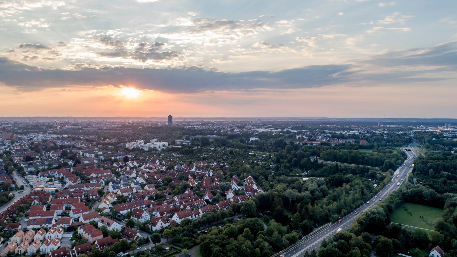 Das Bild zeigt eine Luftaufnahme von Augsburg in einem Dämmerlicht.