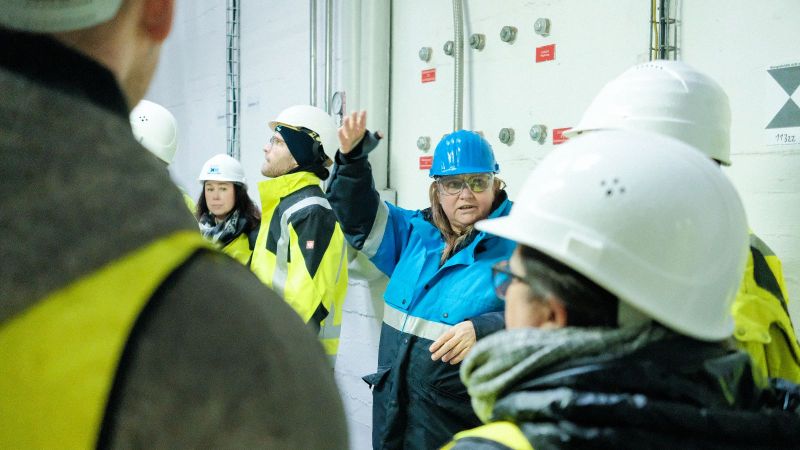 Das Bild zeigt eine Gruppe von Menschen mit Schutzkleidung in der Anlage in Frankfurt-Höchst.