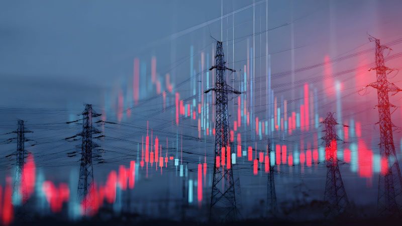 Das Bild zeigt Strommasten und rot und blau leuchtenden Balken eines Balkendiagramms.