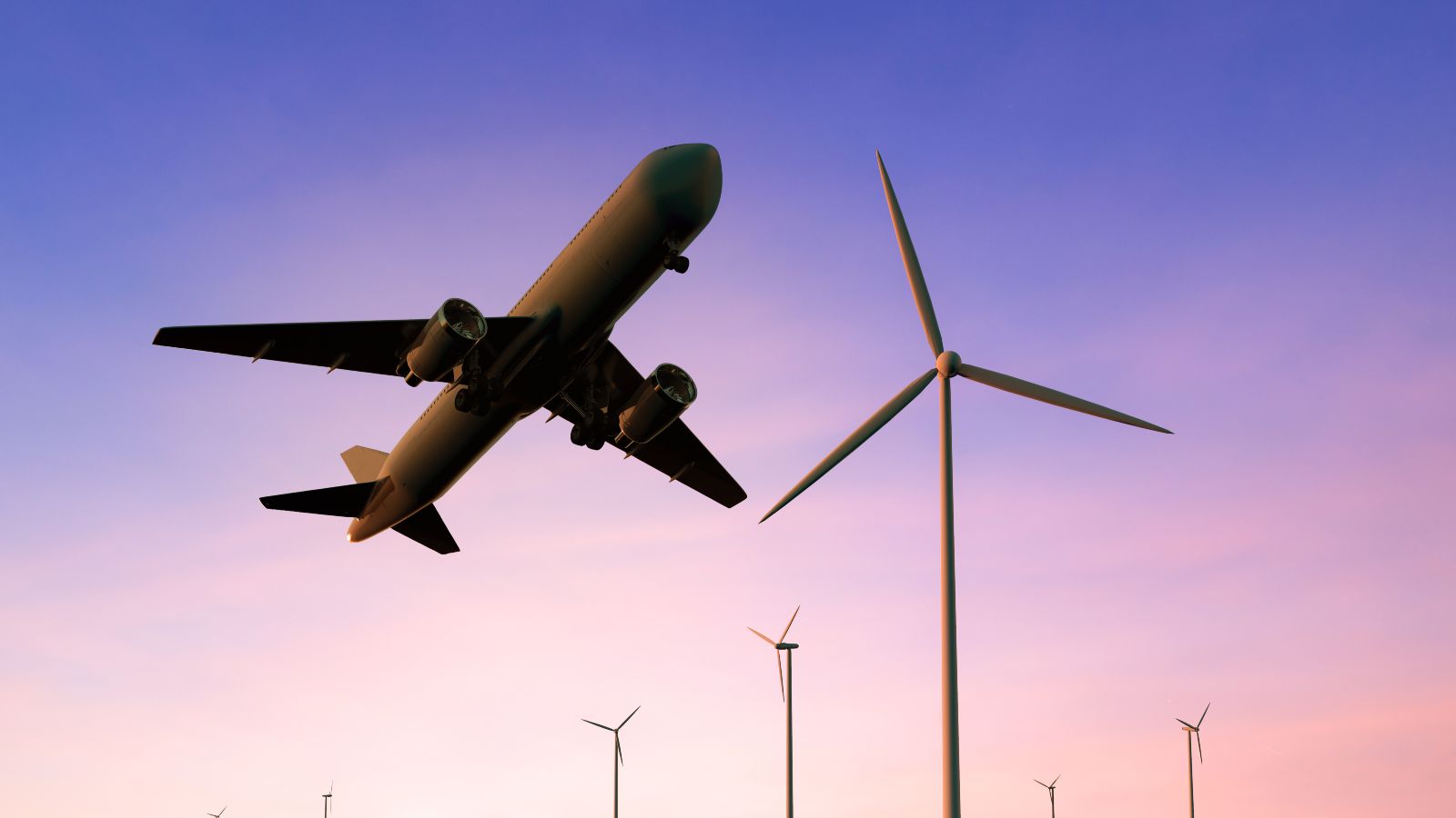 Foto: © phonlamaiphoto - stock.adobe.com Das Bild zeigt ein Flugzeug über einigen Windrädern.