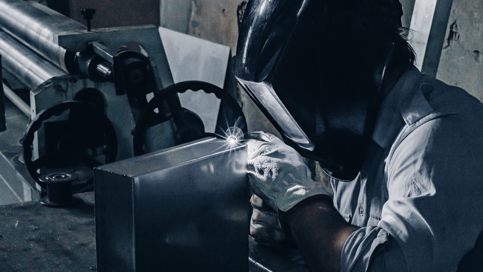 Das Bild zeigt einen Mitarbeiter eines Stahlwerks an einer Schmelzwanne. 