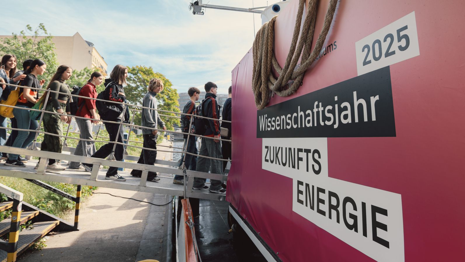 Das Bild zeigt wie mehrere Kinder über eine Schiffsbrücke die MS Wissenschafts zum Wissenschaftsjahr 2025 - Zukunftsenergie betreten.