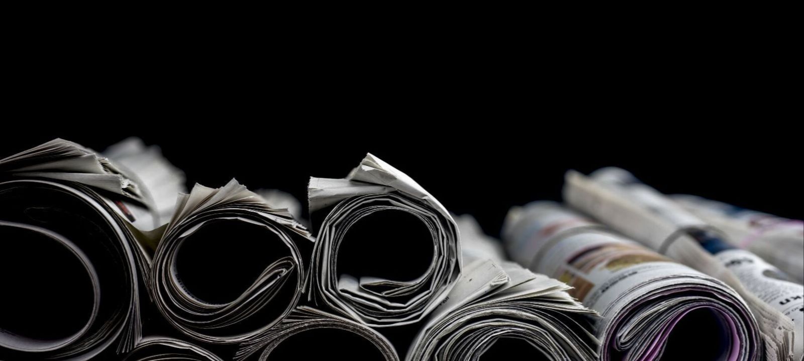 Das Bild zeigt einen Stapel gerollter Zeitungen