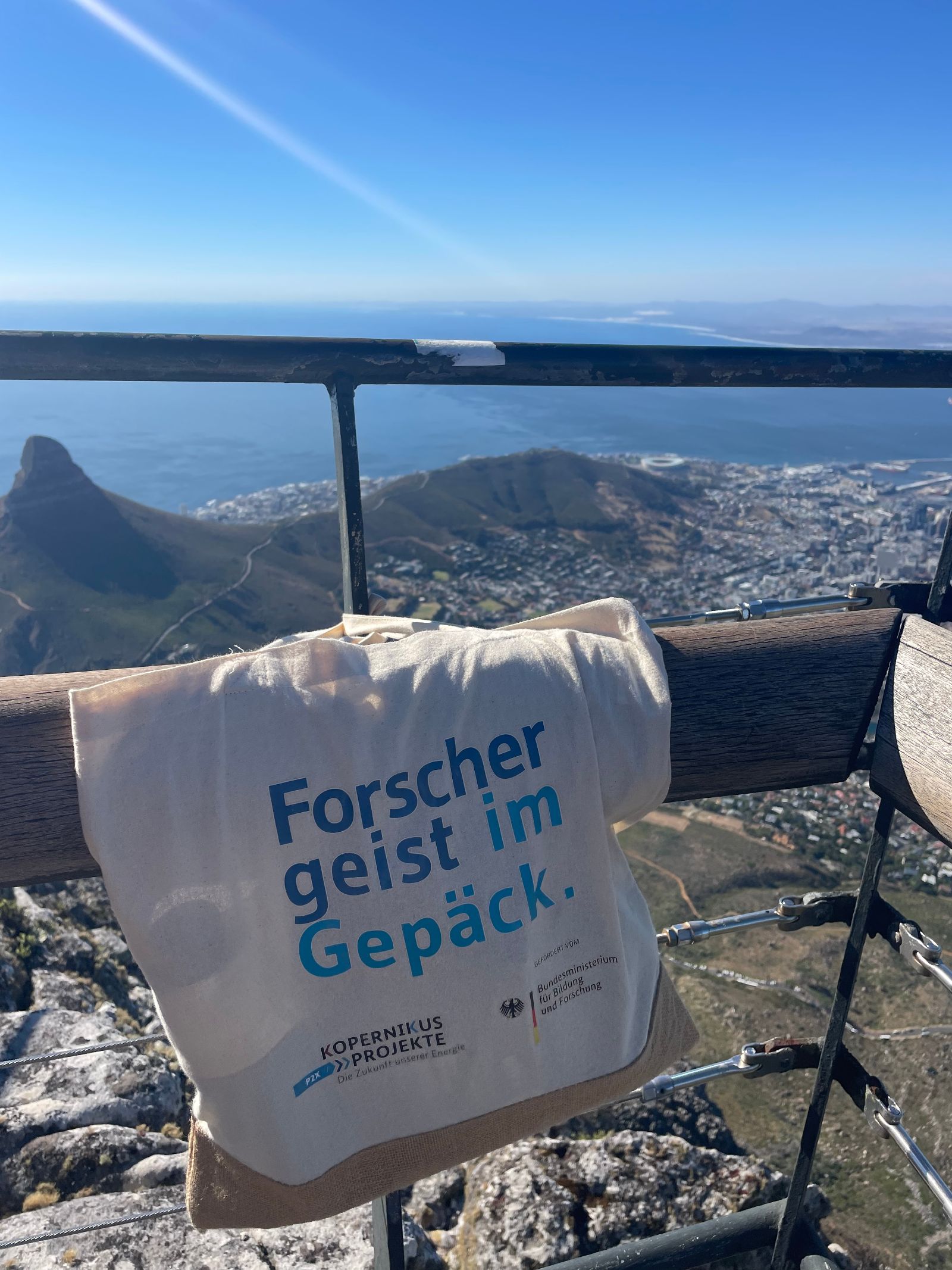 Das Bild zeigt eine P2X-Tasche auf einem Geländer hängend mit dem Panorama von Kapstadt im Hintergrund.